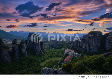 Twilight view of Meteora valley. Mountains, Moni Agias Varvaras Roussanou nunnery, rocks, cliffs. Beautiful sky, clouds. Greece, UNESCO World Heritage Twilight view of Meteora valley. Mountains, Moni Agias Varvaras Roussanou nunnery, rocks, cliffs. Beautiful sky, clouds. Greece, UNESCO World Heritage 73233887