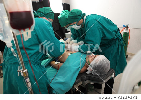 Team of professional surgeons performing operation in hospital operation theater 73234371