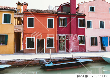 Panoramic view of coloured homes and water canal with boats in Burano Panoramic view of coloured homes and water canal with boats in Burano 73236419