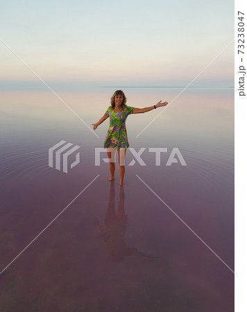 Woman in bright dress in the middle of pink lake Woman in bright dress in the middle of pink lake 73238047