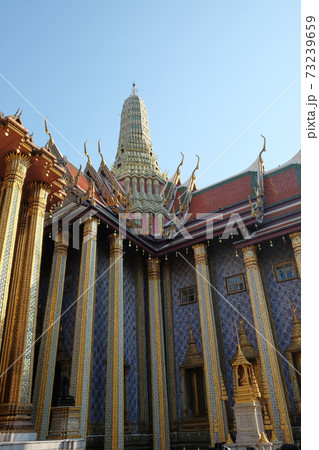 Fragment of the Temple of the Emerald Buddha in Bangkok with a colonnade and a spire. 73239659