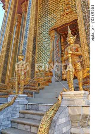 Two gilded sculptures of warriors guard the entrance to the magnificent Buddhist temple. 73239661