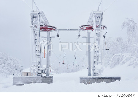 upper tower of the ski lift on a snow-covered hilltop among frosty trees upper tower of the ski lift on a snow-covered hilltop among frosty trees 73240847