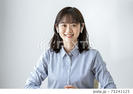 ワイヤレスヘッドホンをつけたカメラ目線の若い女性 ワイヤレスヘッドホンをつけたカメラ目線の若い女性 73241125
