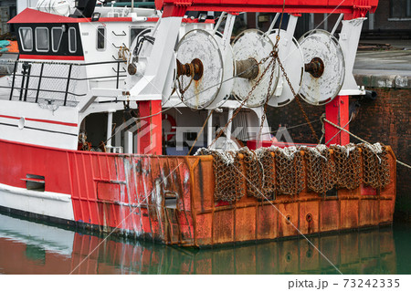 Rusty boat and nets for catching scallops 73242335
