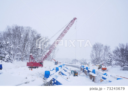 冬の水路工事現場のクレーン車 冬の水路工事現場のクレーン車 73243679