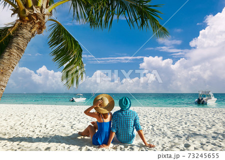 Couple in blue clothes on a beach at Maldives 73245655