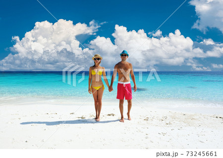 Couple walking on a tropical beach Couple walking on a tropical beach 73245661