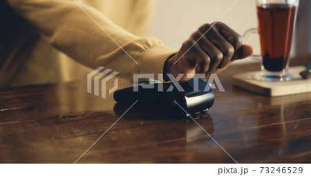 Crop man paying with RFID microchip for cafe meal Crop man paying with RFID microchip for cafe meal 73246529
