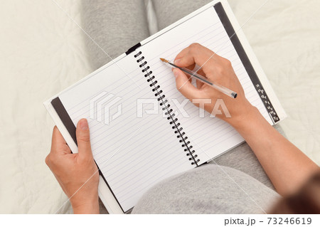 Pregnant woman taking notes in a notebook 73246619