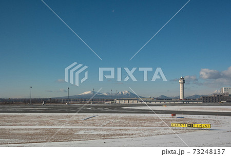雪に覆われた樽前山と新千歳空港の滑走路と管制塔 73248137