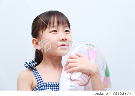 真夏に水着を着て浮き輪で遊ぶ女の子 73252377