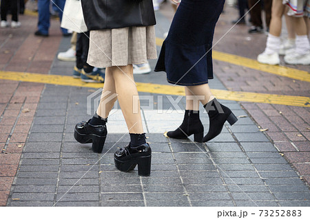 厚底ブーツで渋谷駅前を歩く少女の足元の写真素材