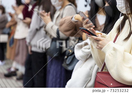 渋谷駅前でスマートフォンを見る若い女性の手元 73253232