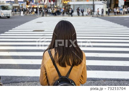 渋谷スクランブル交差点に立つ女性の後ろ姿 73253704