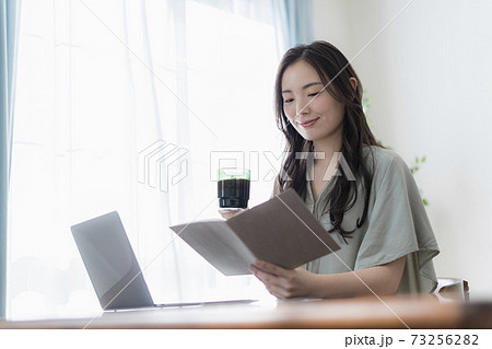 リビングでパソコンを操作する若い女性 リビングでパソコンを操作する若い女性 73256282