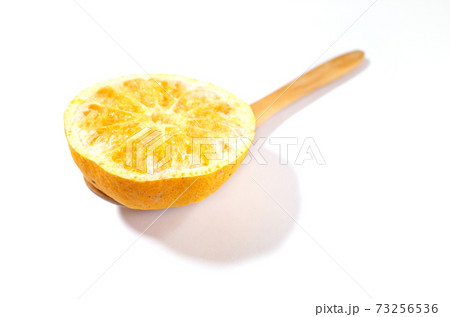 木のスプーンに入ったフリーズドライのみかん 73256536