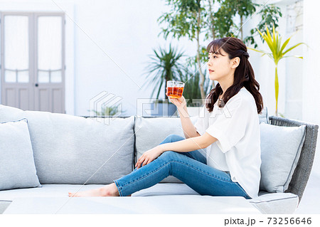 庭のソファーで寛ぐ若い女性 73256646