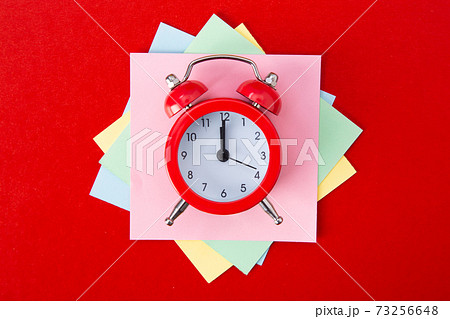 Alarm clock on red background. 73256648
