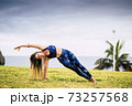 Beautiful young adult woman in balanced pilates exercise position outdoor - sport active people and healthy lifestyle concept - cheerful caucasian female do yoga 73257568
