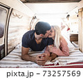 Love and travel with young caucasian couple kiss and love inside a trendy van vehicle during life or vacation leisure activity - concept of people together in tiny house alternative 73257569