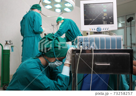 Team of professional surgeons performing operation in hospital , they are holding defibrillator and help while patient will die operation room at hospital Team of professional surgeons performing operation in hospital , they are holding defibrillator and help while patient will die operation room at hospital 73258257