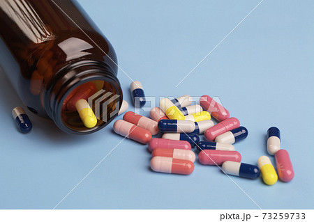 Various medicine capsules and bottle of pills 73259733