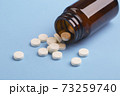 Medicine white pills and glass bottle 73259740