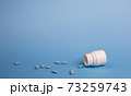 Medicine blue pills and white bottle 73259743
