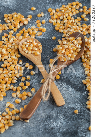 Wooden spoons of sweet corns on marble background 73260237
