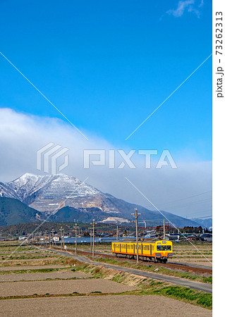 青空の下、冠雪の藤原岳の麓を走る三岐鉄道 73262313