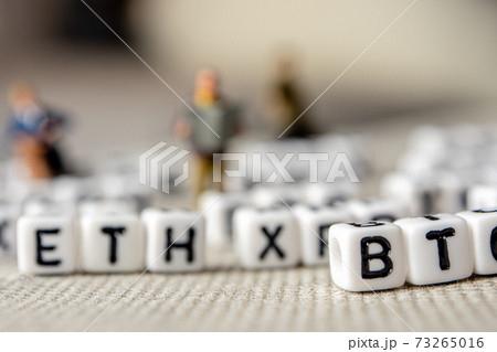 set of popular crypto coins forming rows made of white cubes with black capital letters and miniature businessmen figurines having a team meeting 73265016