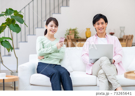 リビングでくつろぐ若い夫婦 リビングでくつろぐ若い夫婦 73265641