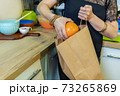 Woman take out fruits from paper bag 73265869
