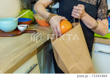 Woman take out fruits from paper bag 73265869