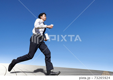 青空のもとで走る若い男性 青空のもとで走る若い男性 73265924