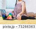 Woman sitting in bed and cleaning laptop keyboard 73266363