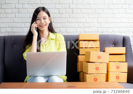 Young asian woman is entrepreneur talking with customer and using laptop computer while order. 73266640