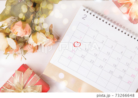 Calendar and flower with memo 14 February Valentine day on desk with blur bokeh background. Calendar and flower with memo 14 February Valentine day on desk with blur bokeh background. 73266648