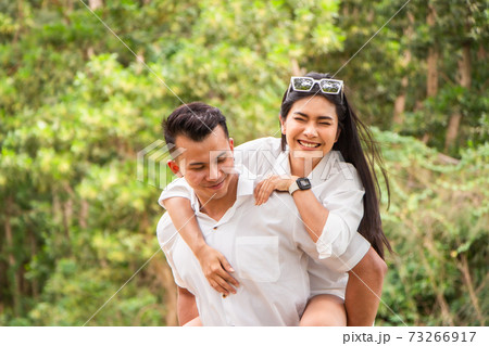 Asian couple love having fun. man and woman wearing casual clothing feeling happiness in park 73266917