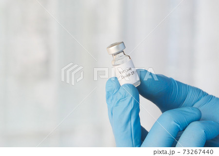 doctor hand in gloves holding coronavirus vaccine, close up doctor hand in gloves holding coronavirus vaccine, close up 73267440