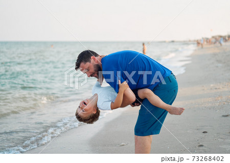 Father son spending time together sea vacation Young dad child little boy walking beach 73268402
