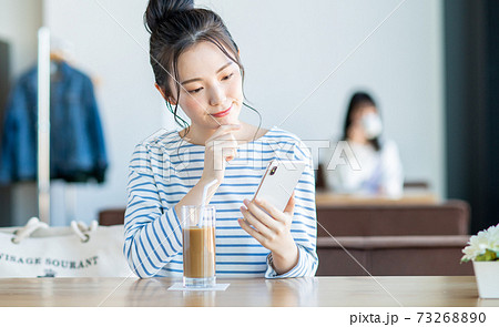 カフェでスマホを見る若い女性 カフェでスマホを見る若い女性 73268890