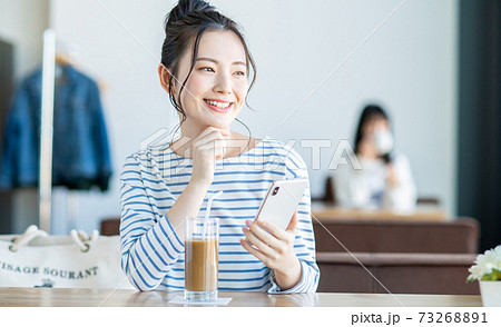 カフェでスマホを見る若い女性 73268891