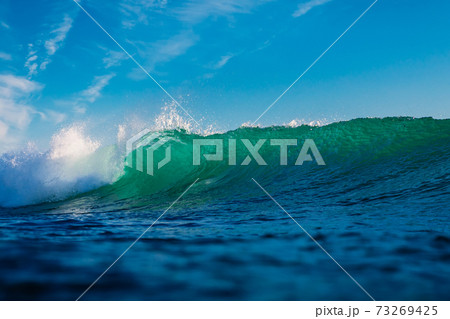 Surfing wave in ocean. Breaking turquoise wave sunny day 73269425