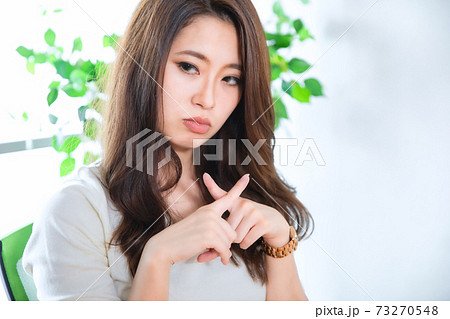 指でバッテンをする女性 73270548