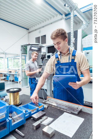 Worker looking for small parts to continue manufacturing stuff in factory Worker looking for small parts to continue manufacturing stuff in factory 73270700
