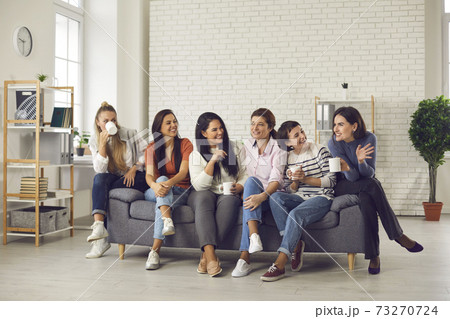 Group of cheerful young women enjoying cup of good coffee and nice chat together Group of cheerful young women enjoying cup of good coffee and nice chat together 73270724