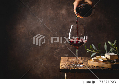 Pouring red wine into the glass 73271903