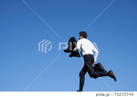 マスクをつけて走る男の後姿の写真素材